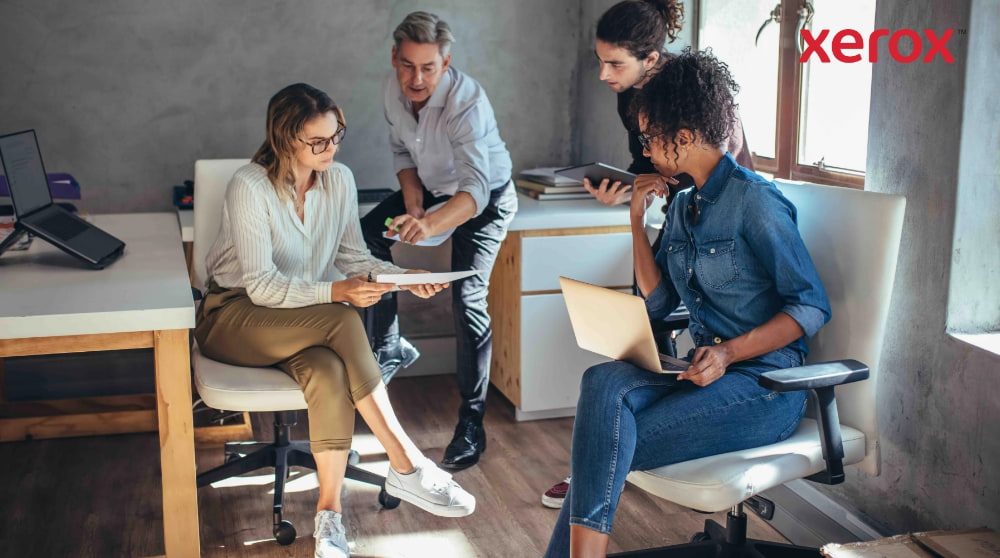 Vier collega's werken samen in een modern kantoor. Vier collega's werken samen in een modern kantoor.