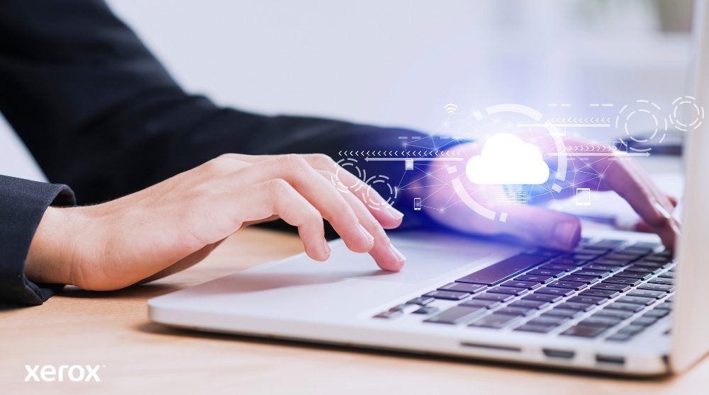 Xerox® Workplace Cloud en Suite: Cloudconnectiviteit Er worden iemands handen getoond die op een laptoptoetsenbord typen, met een gloeiend wolkpictogram en netwerkverbindingen over de afbeelding heen, wat symbool staat voor cloudconnectiviteit en digitale workflows.