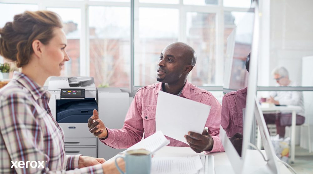 Xerox® Workplace Cloud en Suite: Gecentraliseerd vlootbeheer Een persoon bekijkt gegevens op een laptopscherm, met een digitale overlay van verschillende apparaatpictogrammen (printers, mobiele apparaten) en verbonden lijnen, wat symbool staat voor gecentraliseerd vlootbeheer voor Xerox Workplace Solutions.